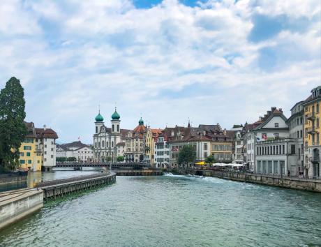 Vue d’une ville suisse au bord d’une rivière, illustrant la création d’un CV suisse
