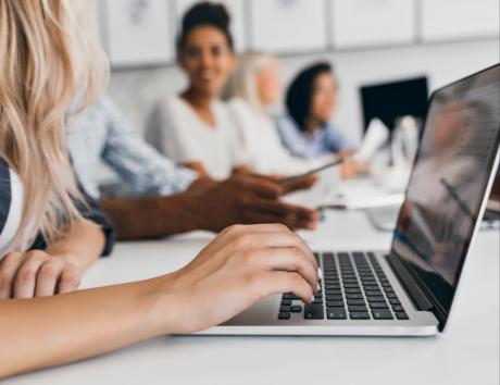 Candidat rédigeant son CV sur ordinateur portable, en environnement professionnel.