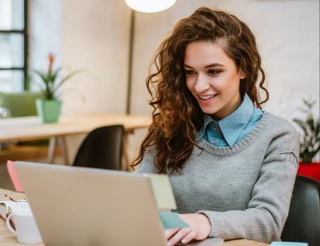 Femme tapant sur un ordinateur, illustrant la création d’un CV sans expérience professionnelle
