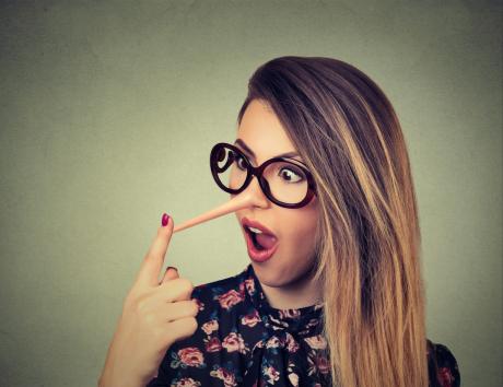 Femme avec lunettes et nez allongé façon Pinocchio, illustrant le mensonge sur un CV