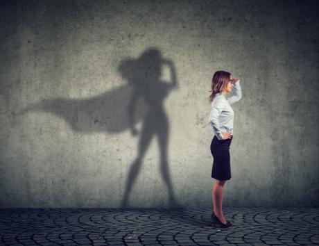 Femme debout, les mains sur les hanches, pour illustrer la définition d’un objectif professionnel sur un CV.