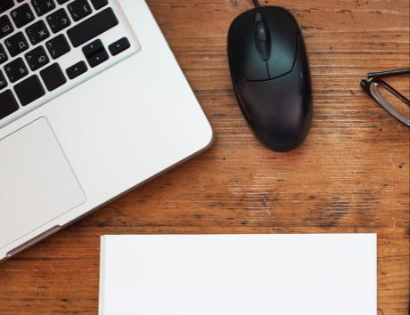 Ordinateur portable sur un bureau avec feuille vierge, illustrant la création d’un CV chronologique professionnel.