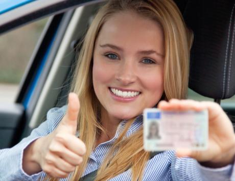 Jeune femme tenant son permis dans une voiture, illustration du permis de conduire sur un CV